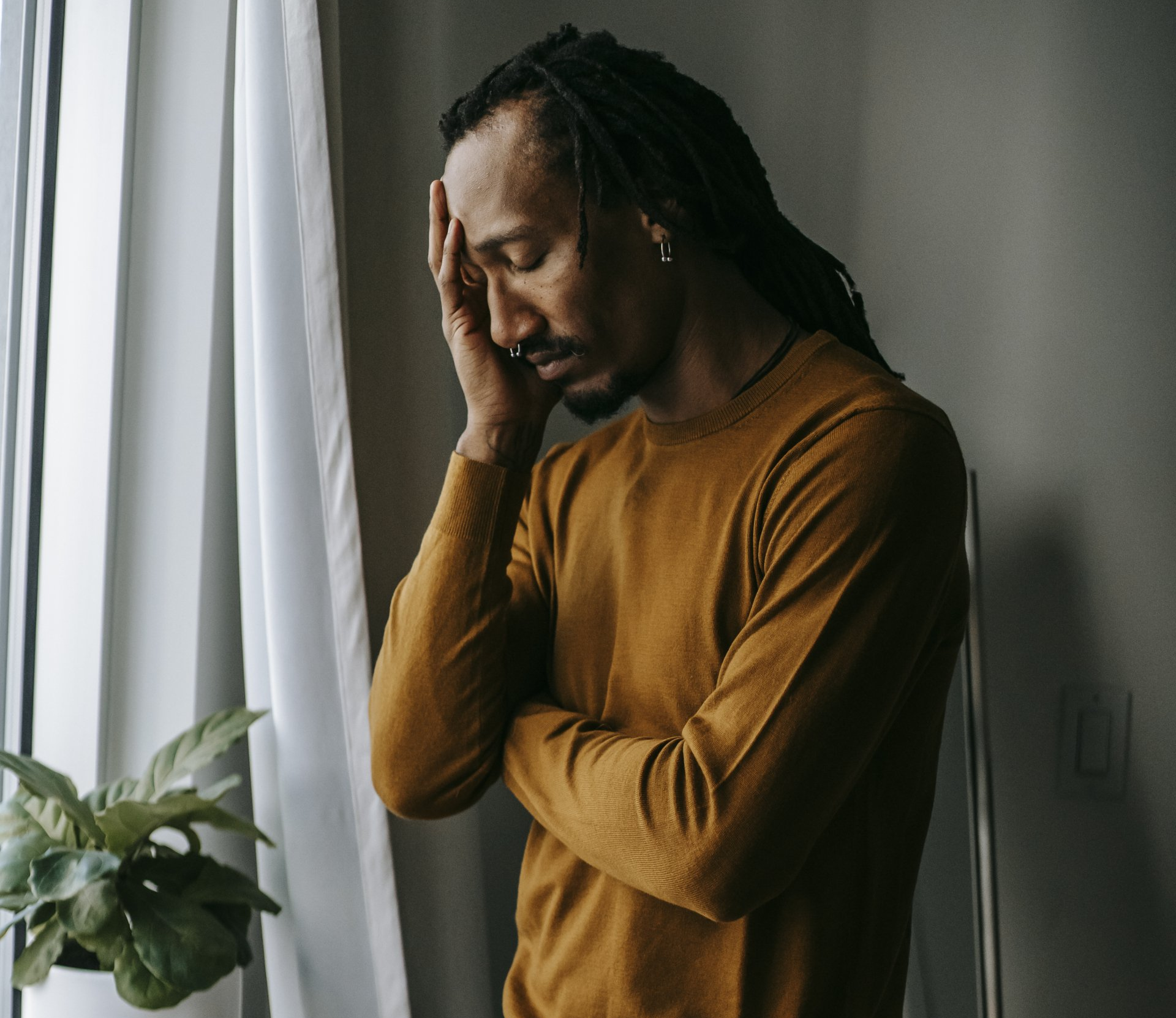 man standing with hand on head in pain