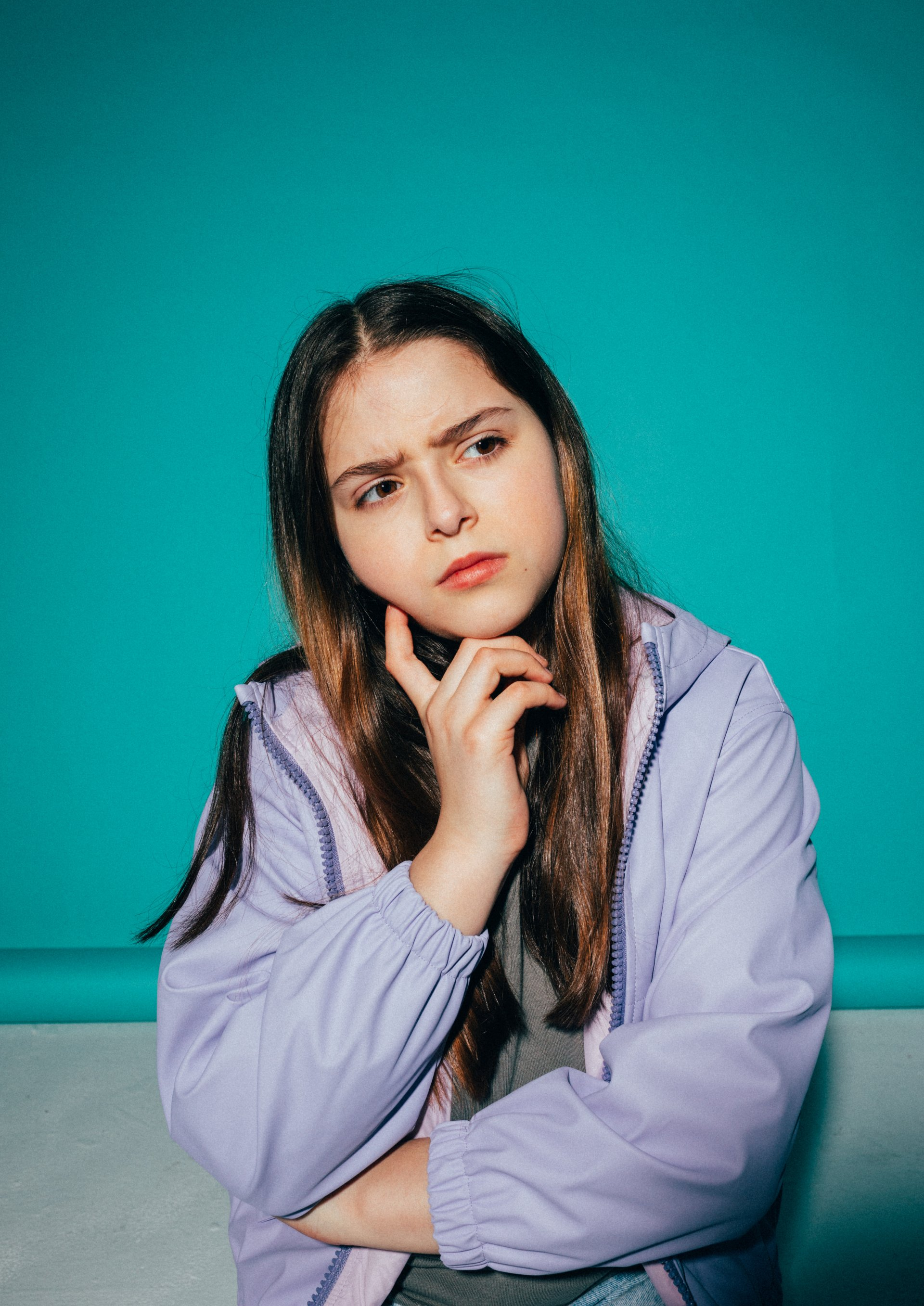 young woman with hand on face thinking