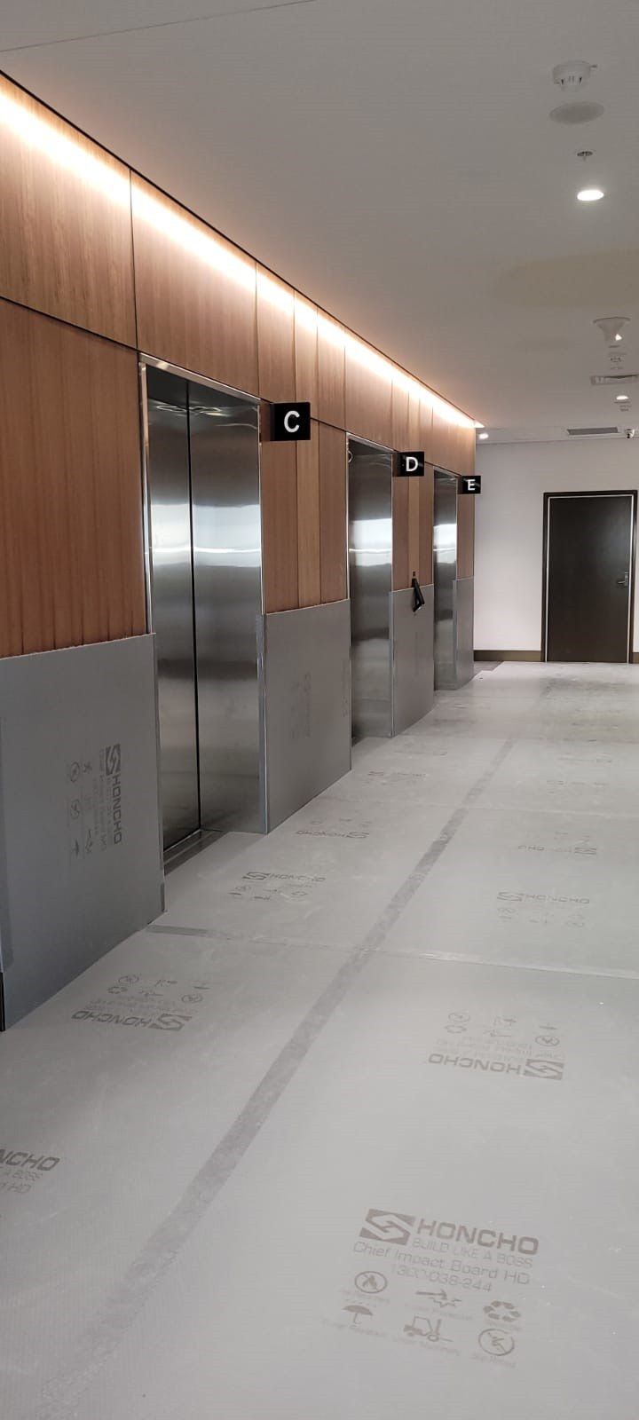 Honcho Chief Board MD protecting Timber Veneer in a lift Lobby: Erilyan - St Leonards