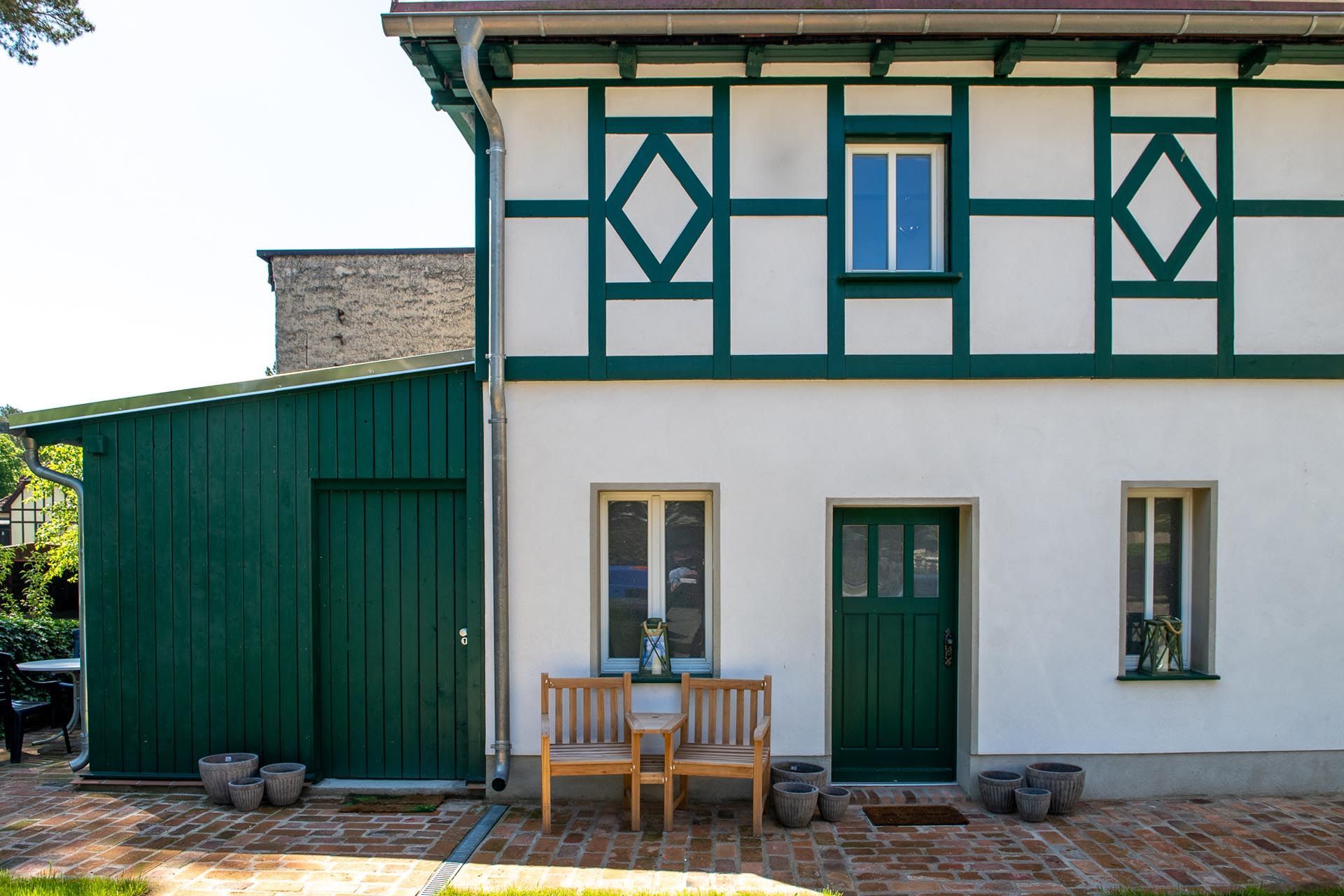 Ein weißes Haus mit grünen Verzierungen und einer grünen Tür