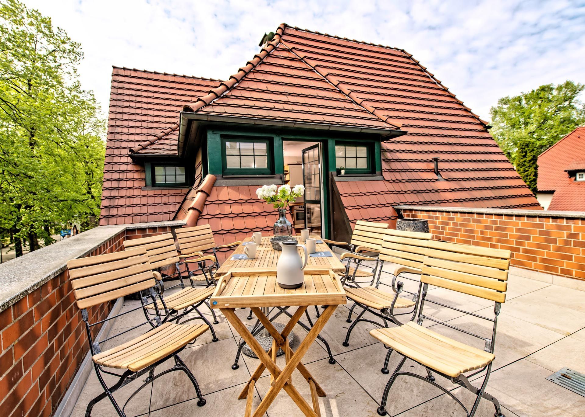 Auf dem Balkon eines Hauses stehen ein Tisch und Stühle.
