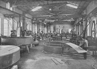 Ein Schwarzweißfoto einer Fabrik mit vielen Maschinen.