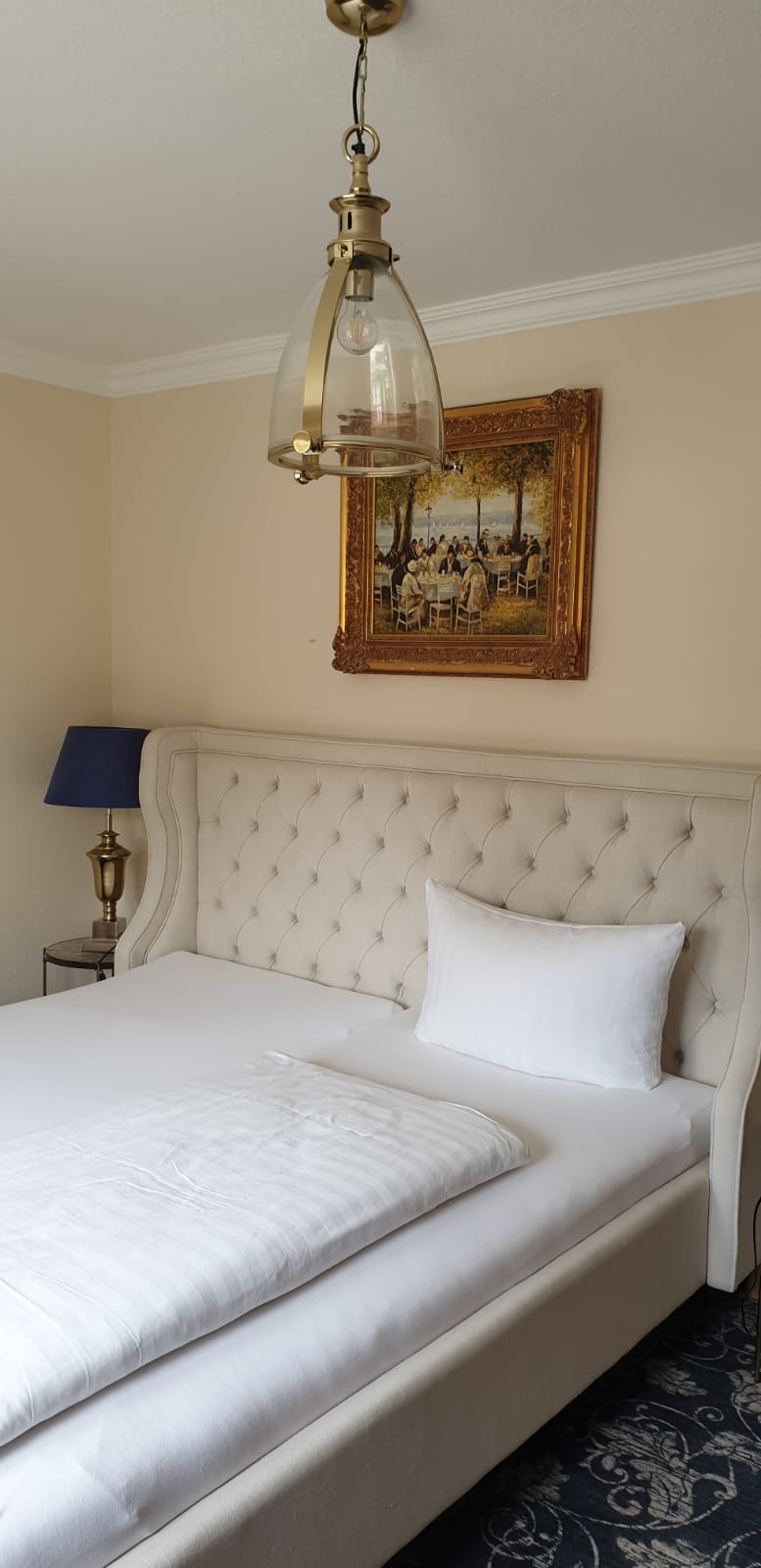 An der Wand über dem Bett im Schlafzimmer hängt ein Gemälde.