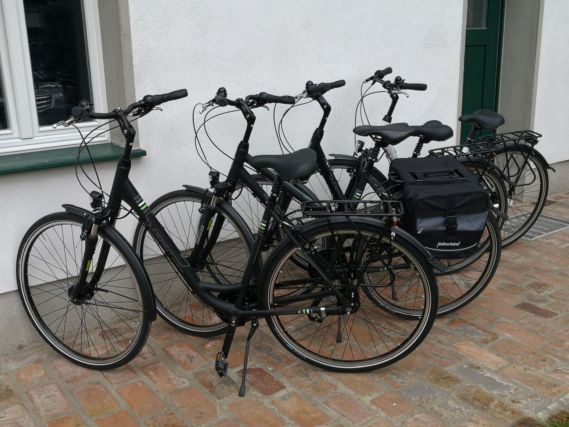 Drei Fahrräder stehen vor einem weißen Gebäude