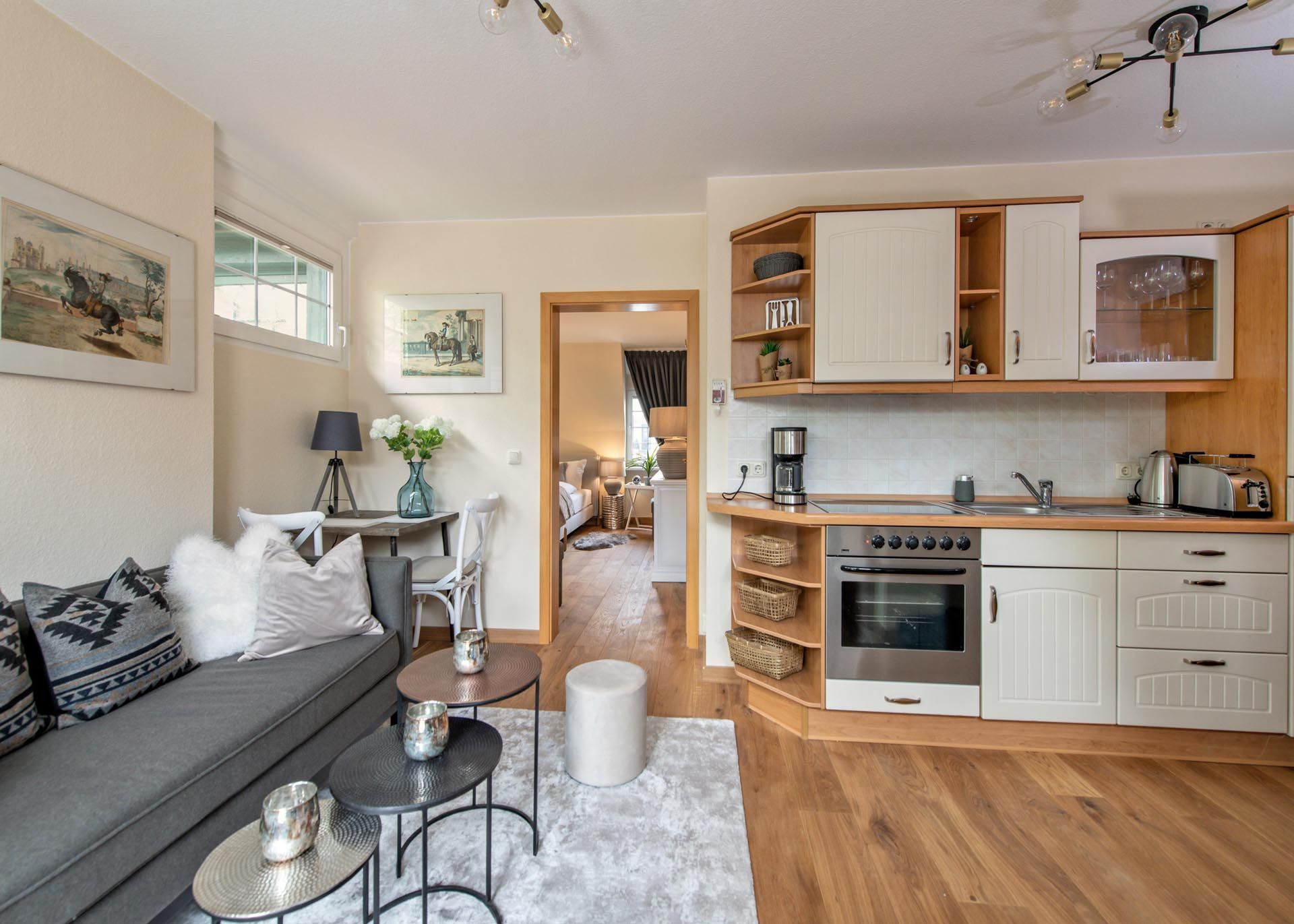 Ein Wohnzimmer mit Couch, Tischen und Küche.