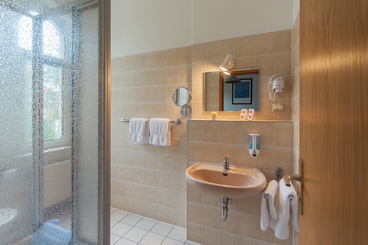 Ein Badezimmer mit Waschbecken, Spiegel und Dusche.