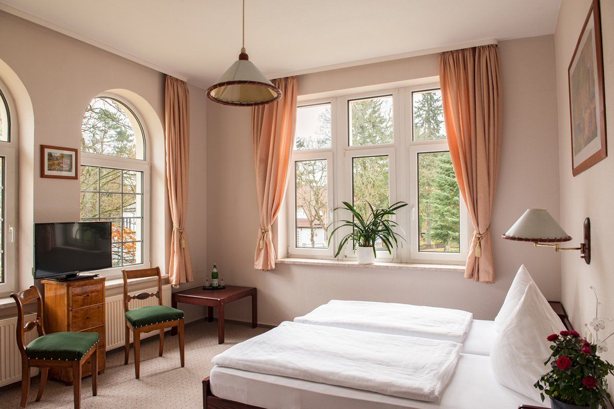 Ein Hotelzimmer mit Bett, Stühlen, Tisch und Fernseher.