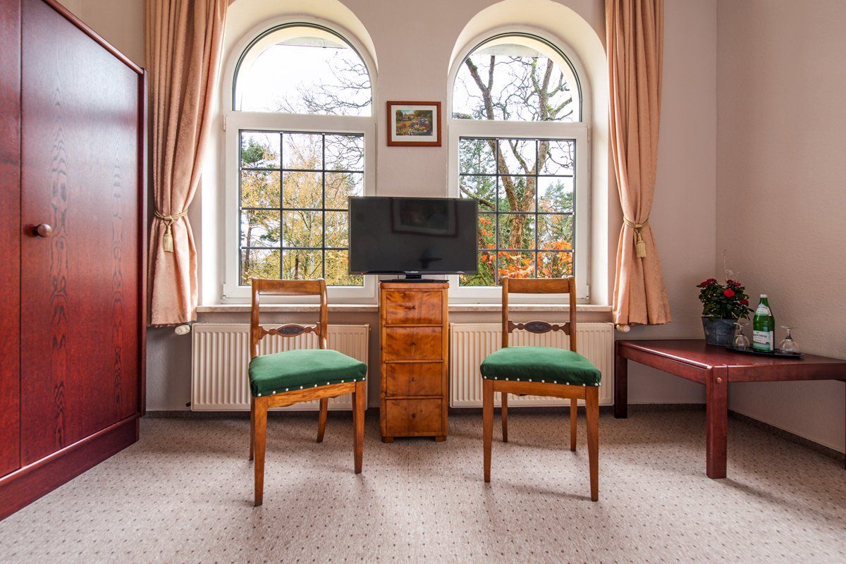 Ein Raum mit zwei Stühlen und einem Flachbildfernseher