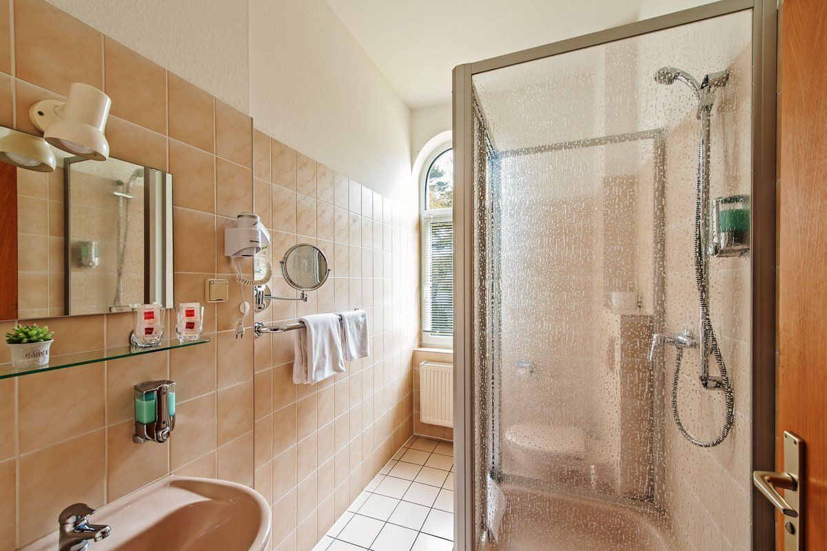 Ein Badezimmer mit Waschbecken, Spiegel und Dusche.