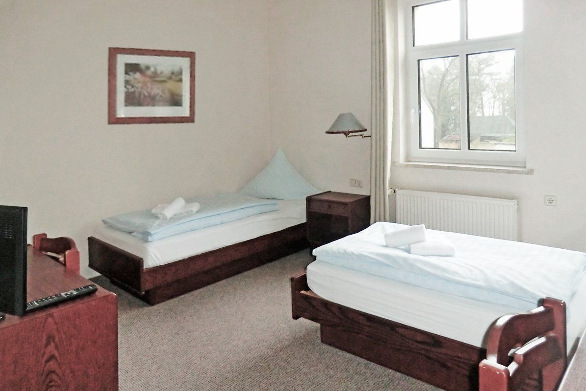 Ein Hotelzimmer mit zwei Betten und einem Fernseher