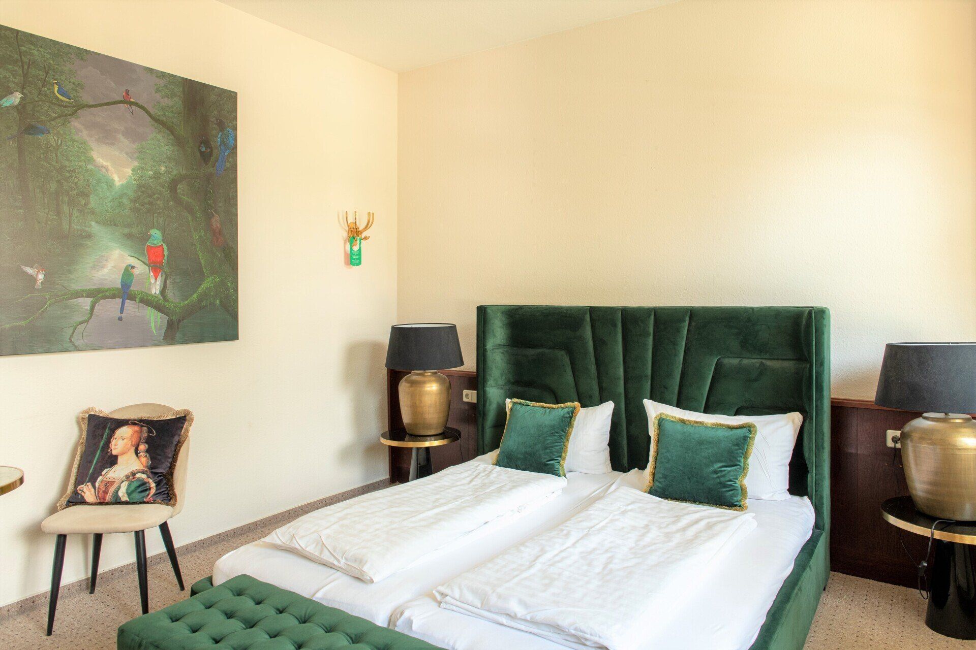 Ein Hotelzimmer mit zwei Betten und einem Gemälde an der Wand.