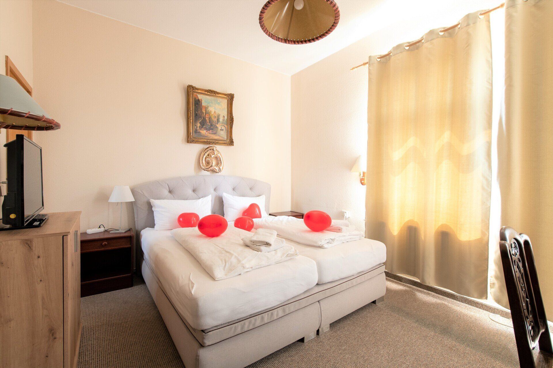 Ein Hotelzimmer mit zwei Betten und einem Fernseher.