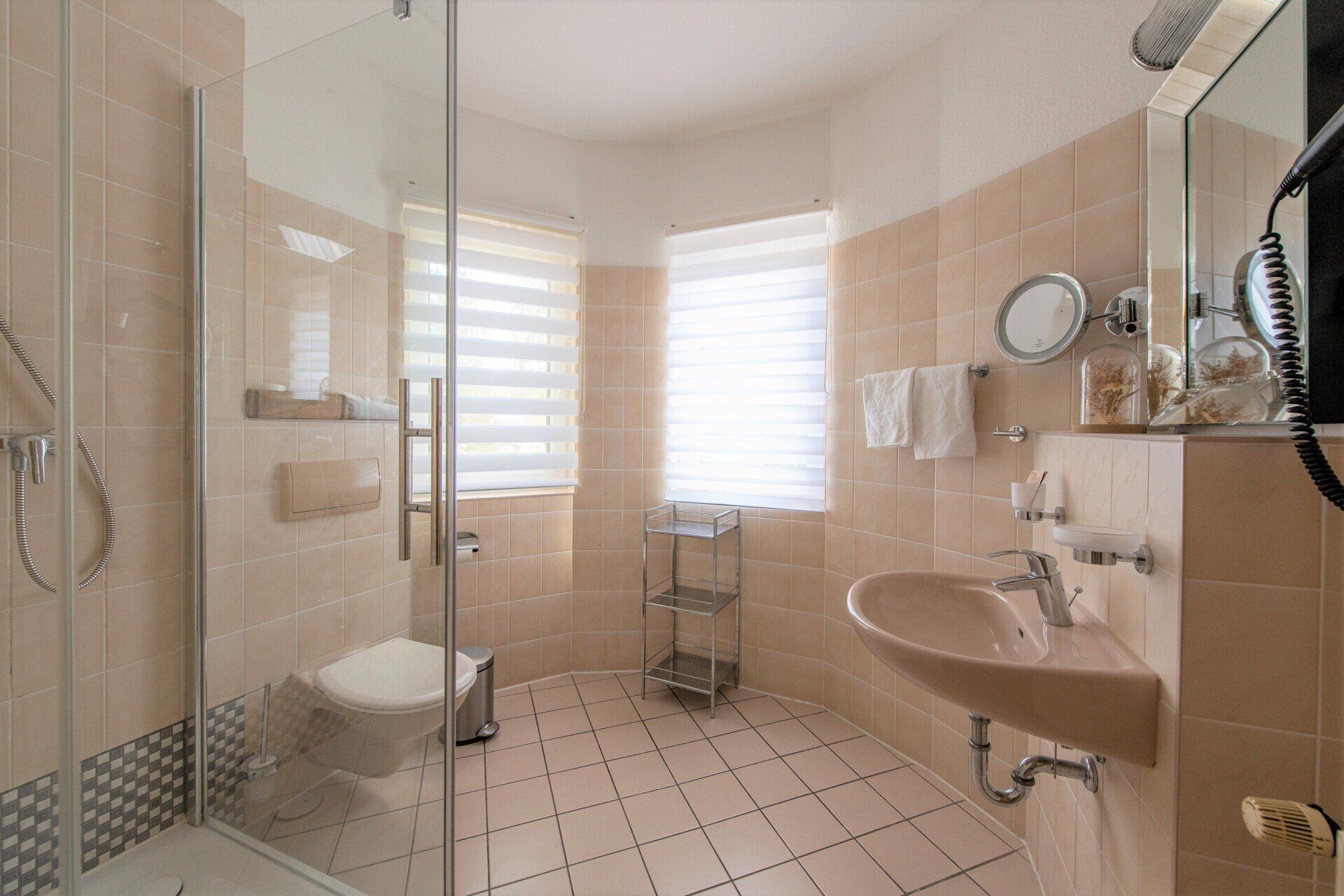 Ein Badezimmer mit Waschbecken, Toilette, Dusche und Spiegel.