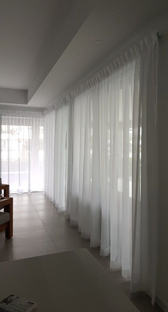 Bedroom With Curved Windows, Gray Curtains, Armchair, Desk, and Beds — Instyle Curtains & Blinds in Bungalow, QLD