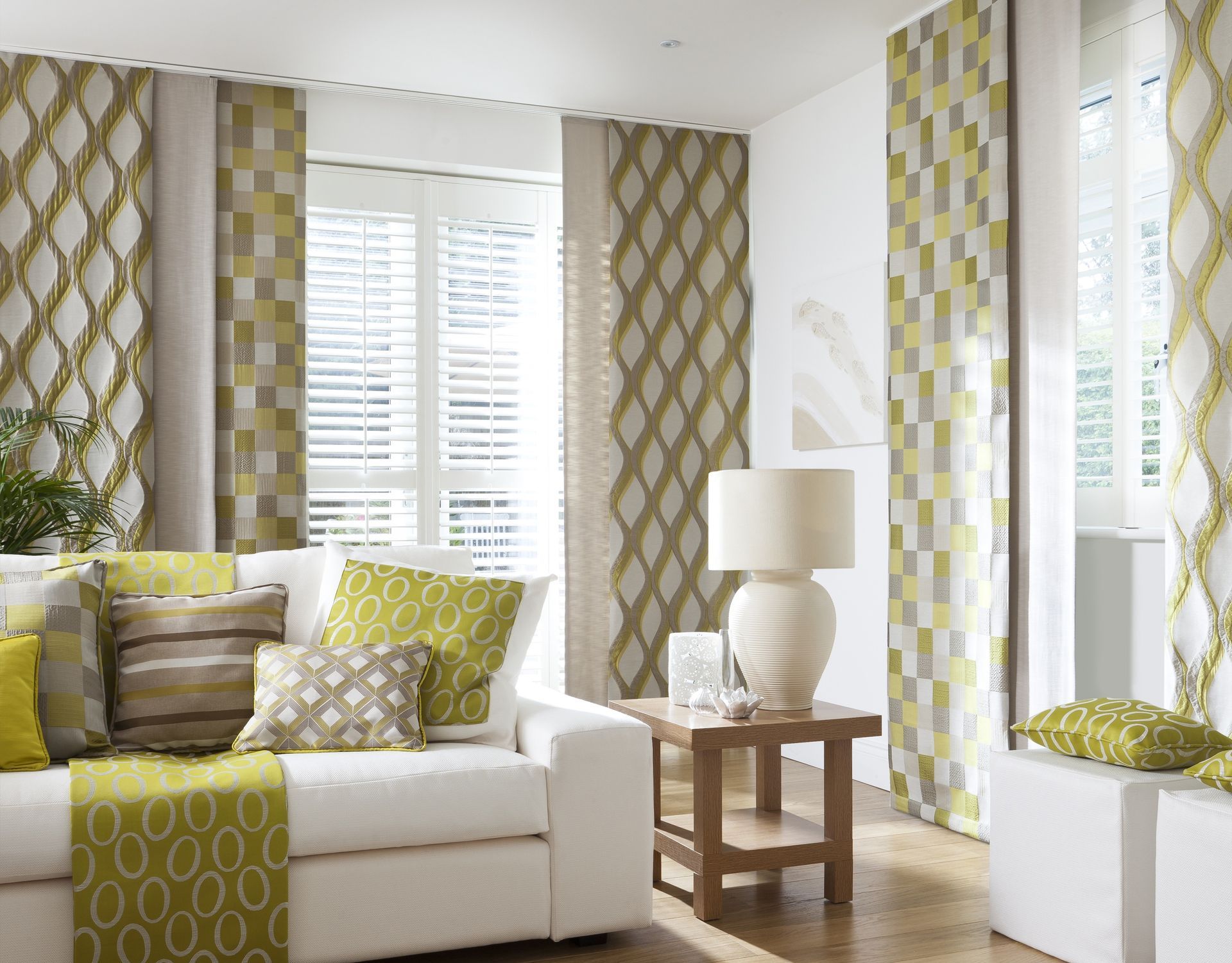 Gray Roller Blind Partially Covering Window, Next to a Potted Snake Plant — Instyle Curtains & Blinds in Bungalow, QLD