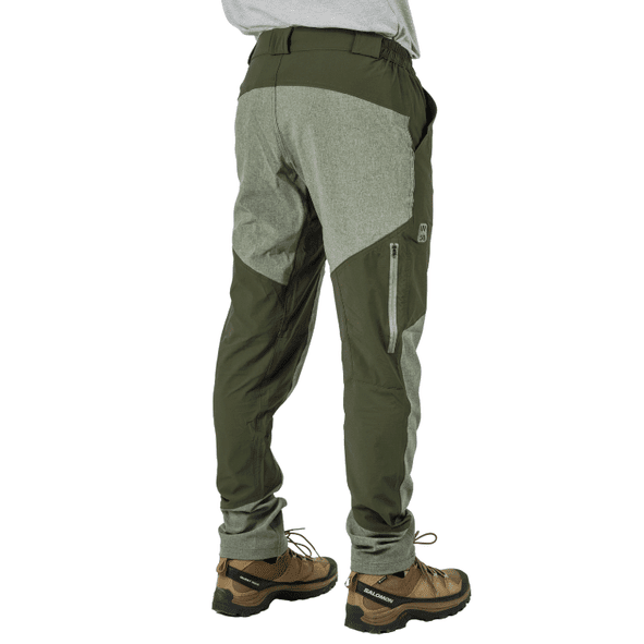 Hombre con pantalones de exterior verde oliva y gris y botas de senderismo marrones.