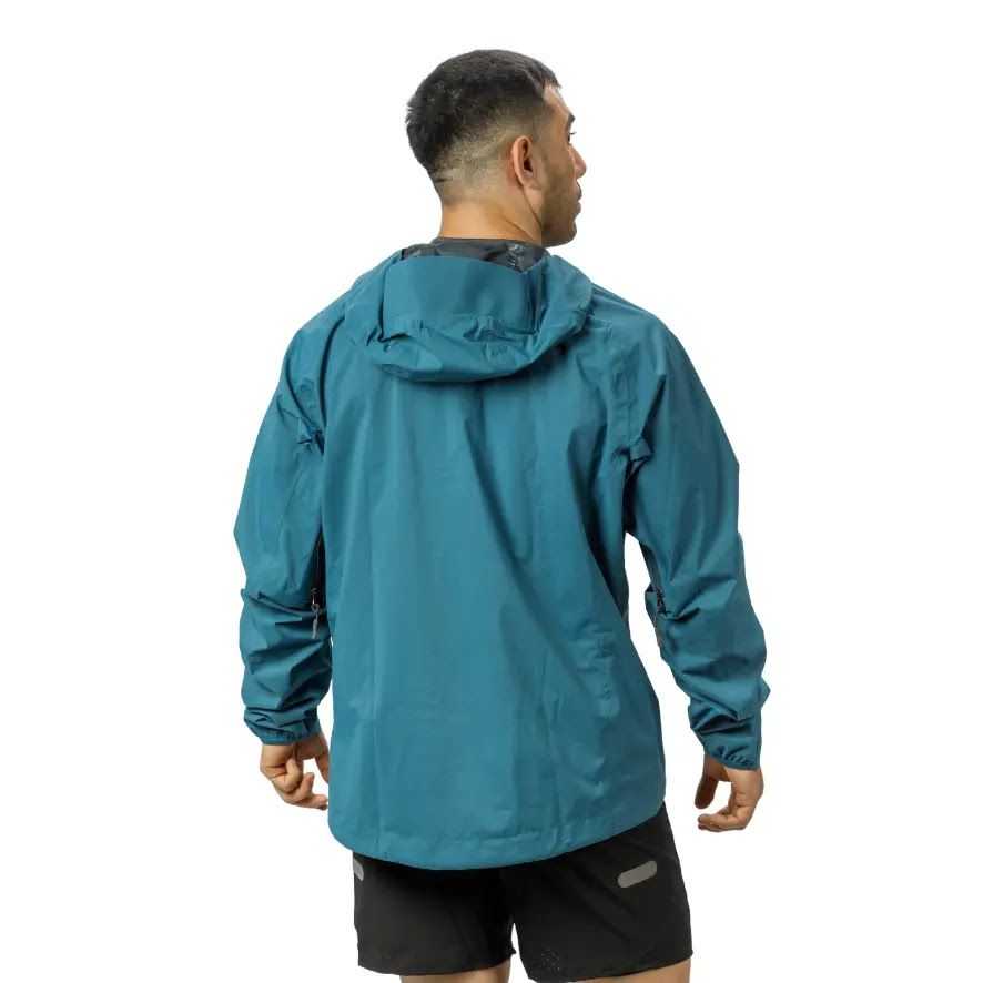 Hombre con chaqueta azul verdosa con capucha, subida con cremallera, sonriendo.