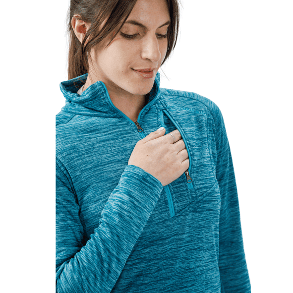Mujer con jersey polar color verde azulado, abriendo la cremallera del bolsillo del pecho.
