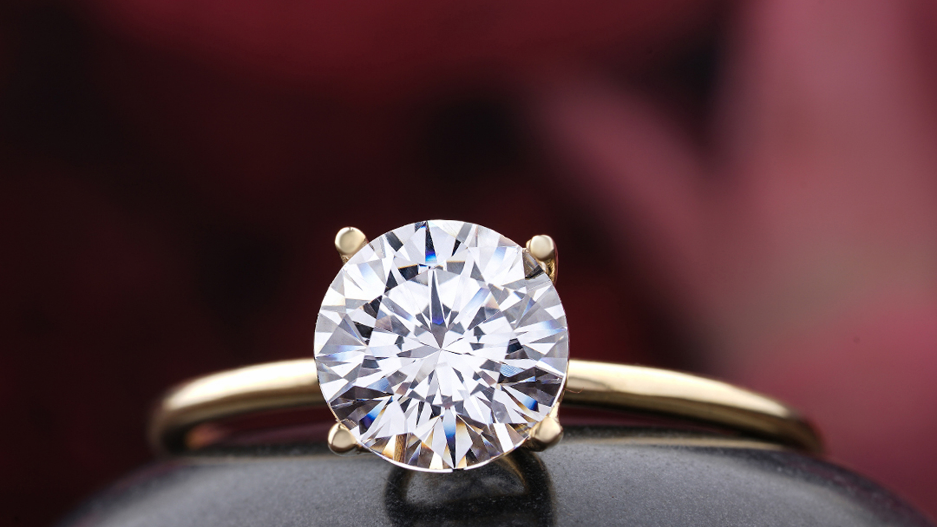 Two hands holding each other in a car, with a diamond ring visible on one hand.