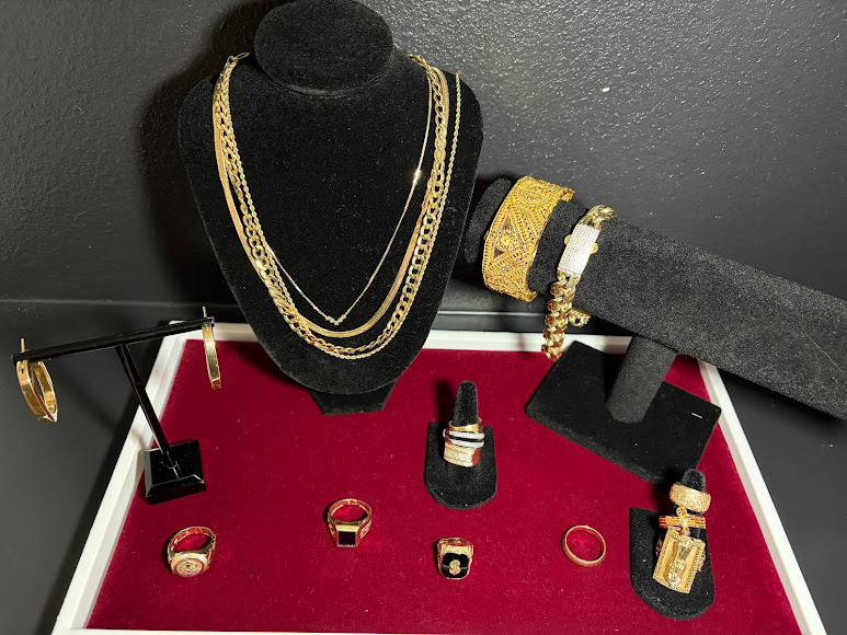 Hand holding a bowl full of tangled gold-colored chains and jewelry scraps