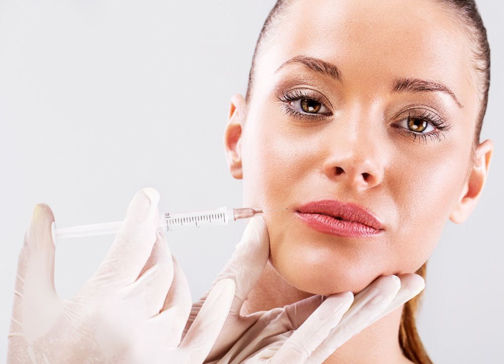 A woman is getting a botox injection in her face.
