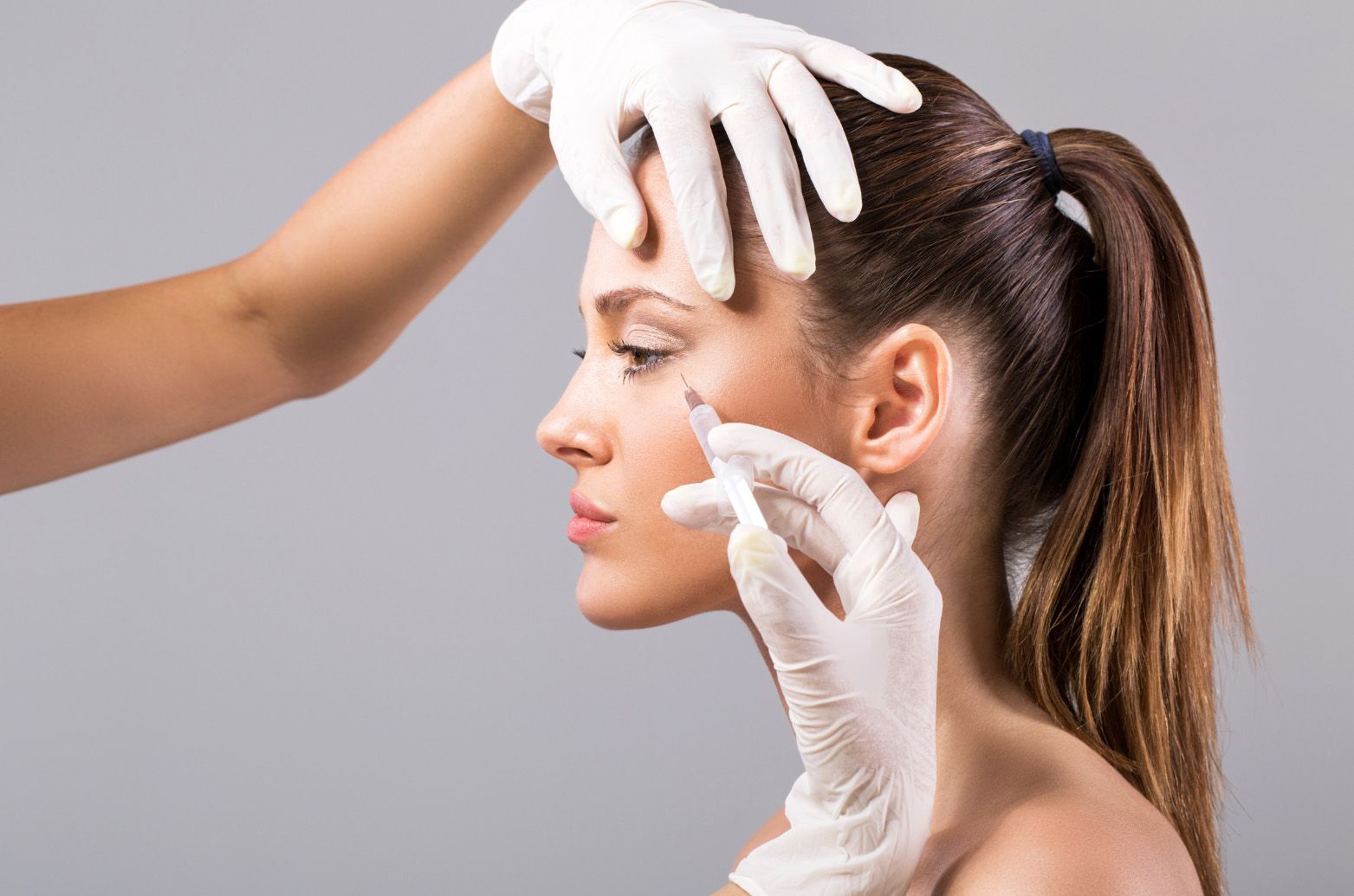 A woman is getting a botox injection in her face.