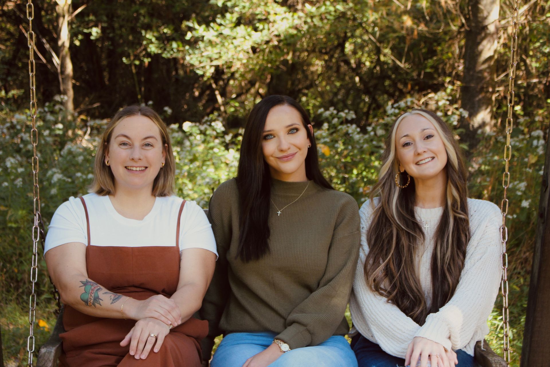 A group of women are posing for a picture in front of a christmas tree.