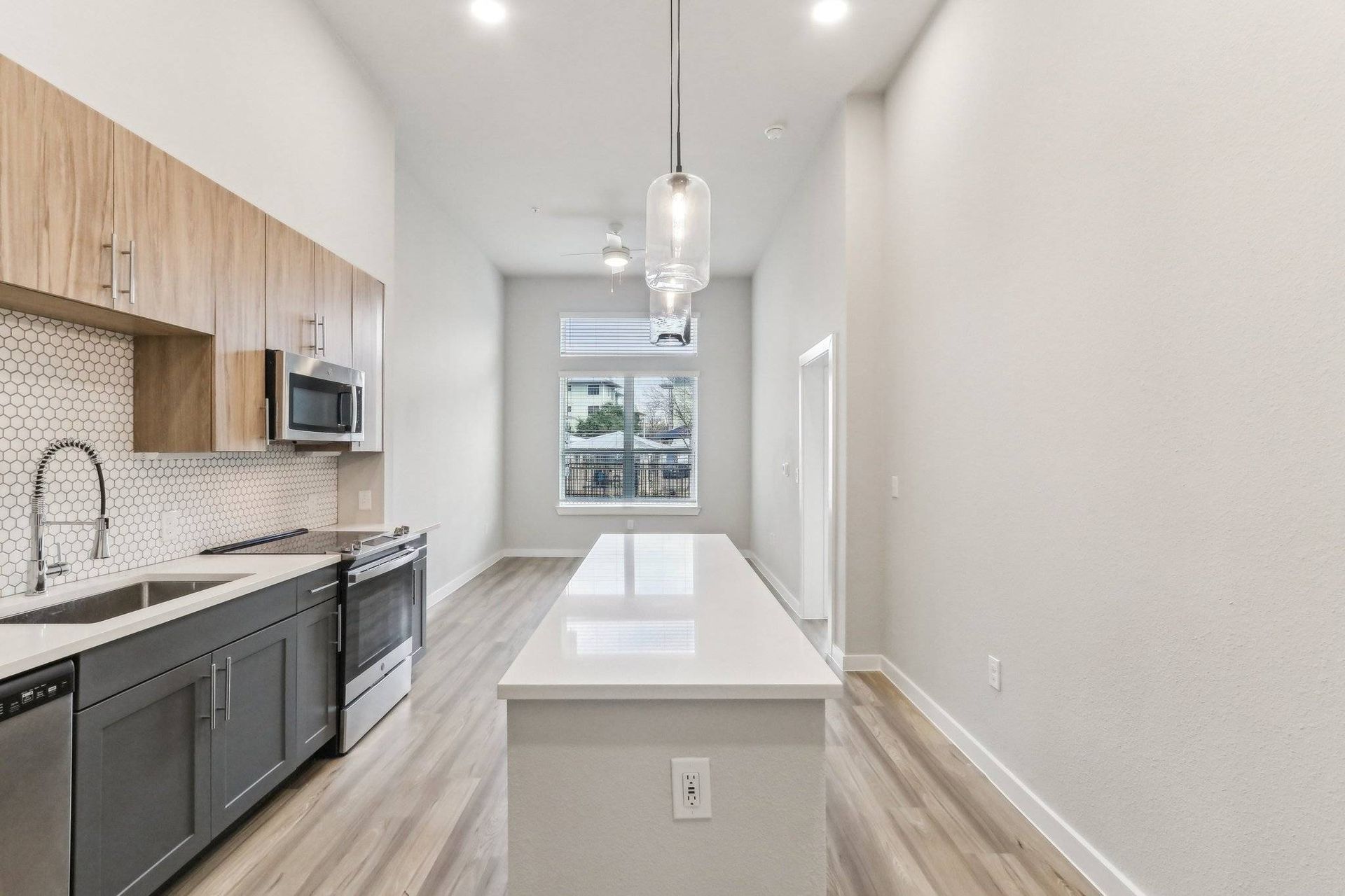 Modern kitchen with an island, stainless-steel appliances, and wood cabinets.
