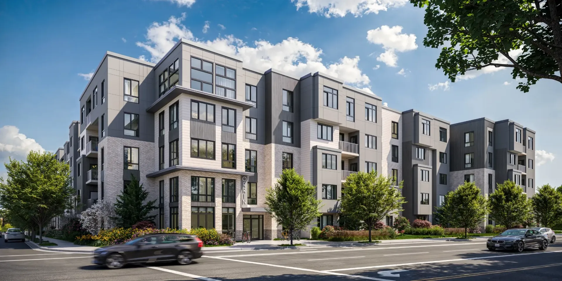 Exterior view of a modern multi-building apartment complex along a street.