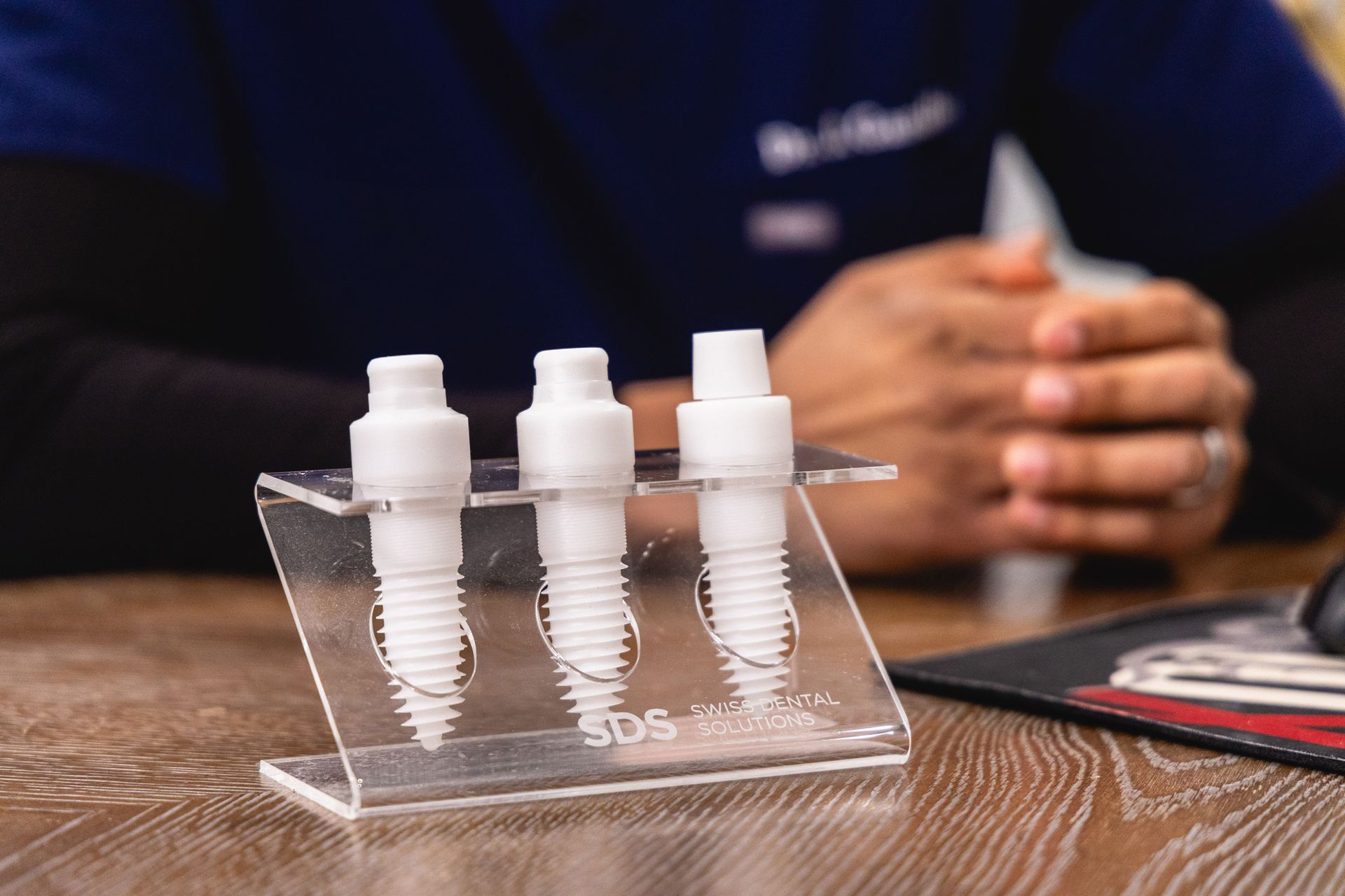 Dr. Gandhi holding a ceramic implant model