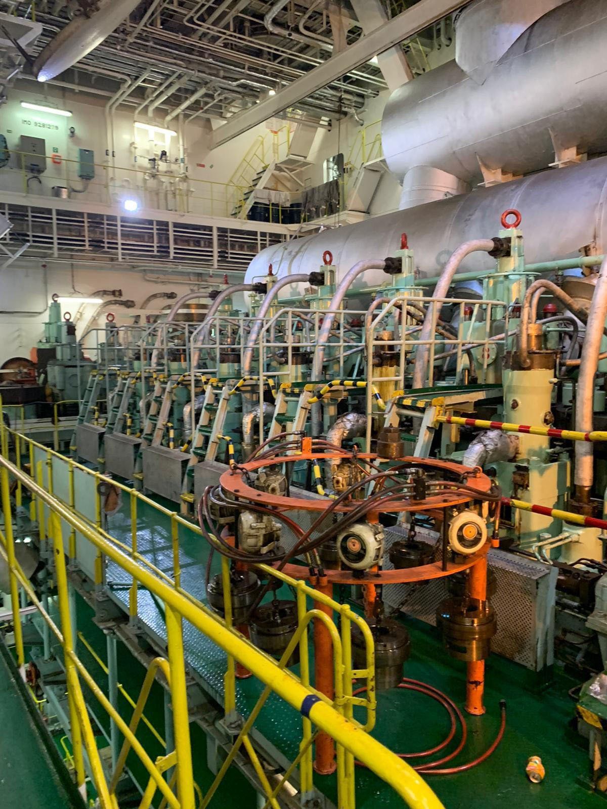 A man in blue overalls walks past a turbine