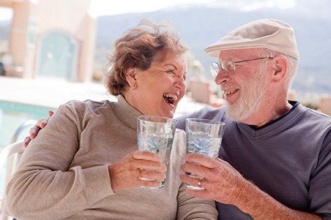 Senior Couple Smiling And Having Drinks — Water Pressure System in Damascus, OR