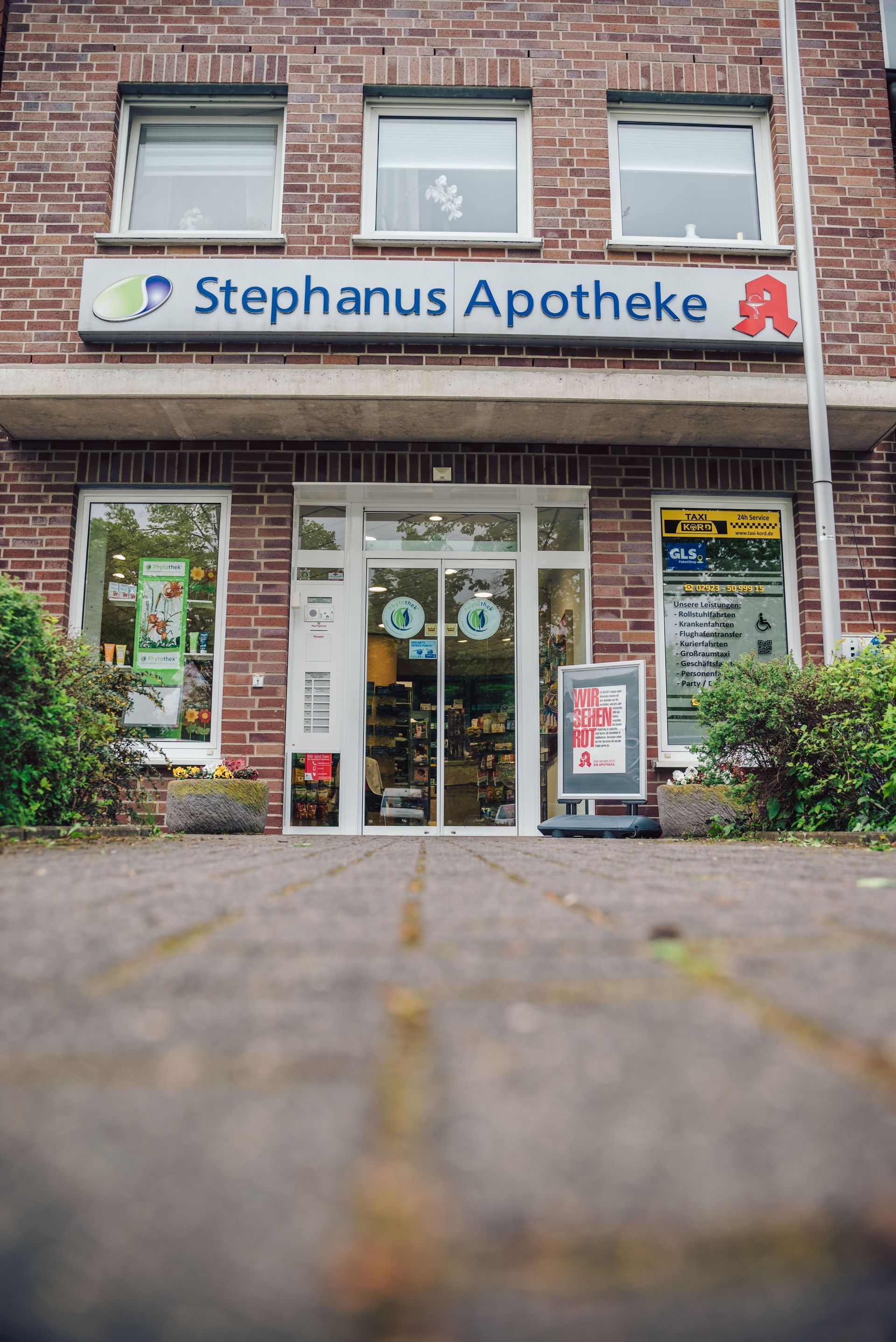 Die Vorderseite eines Backsteingebäudes mit einem Schild mit der Aufschrift „Stephanus Apotheke“.