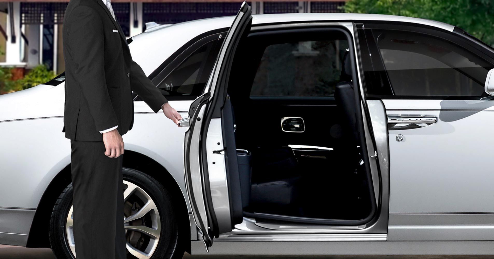 A Man in a Suit is Opening the Door of a White Car — Territory Limousine Service in Marrara, NT