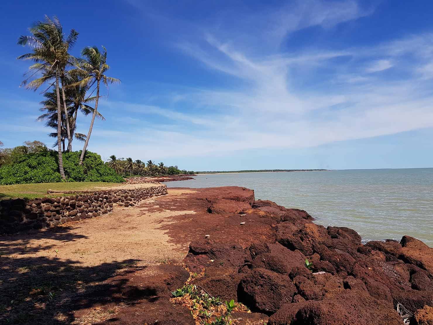 A Beach With Rocks and Palm Trees on a Sunny Day — Territory Limousine Service in Darwin, NT