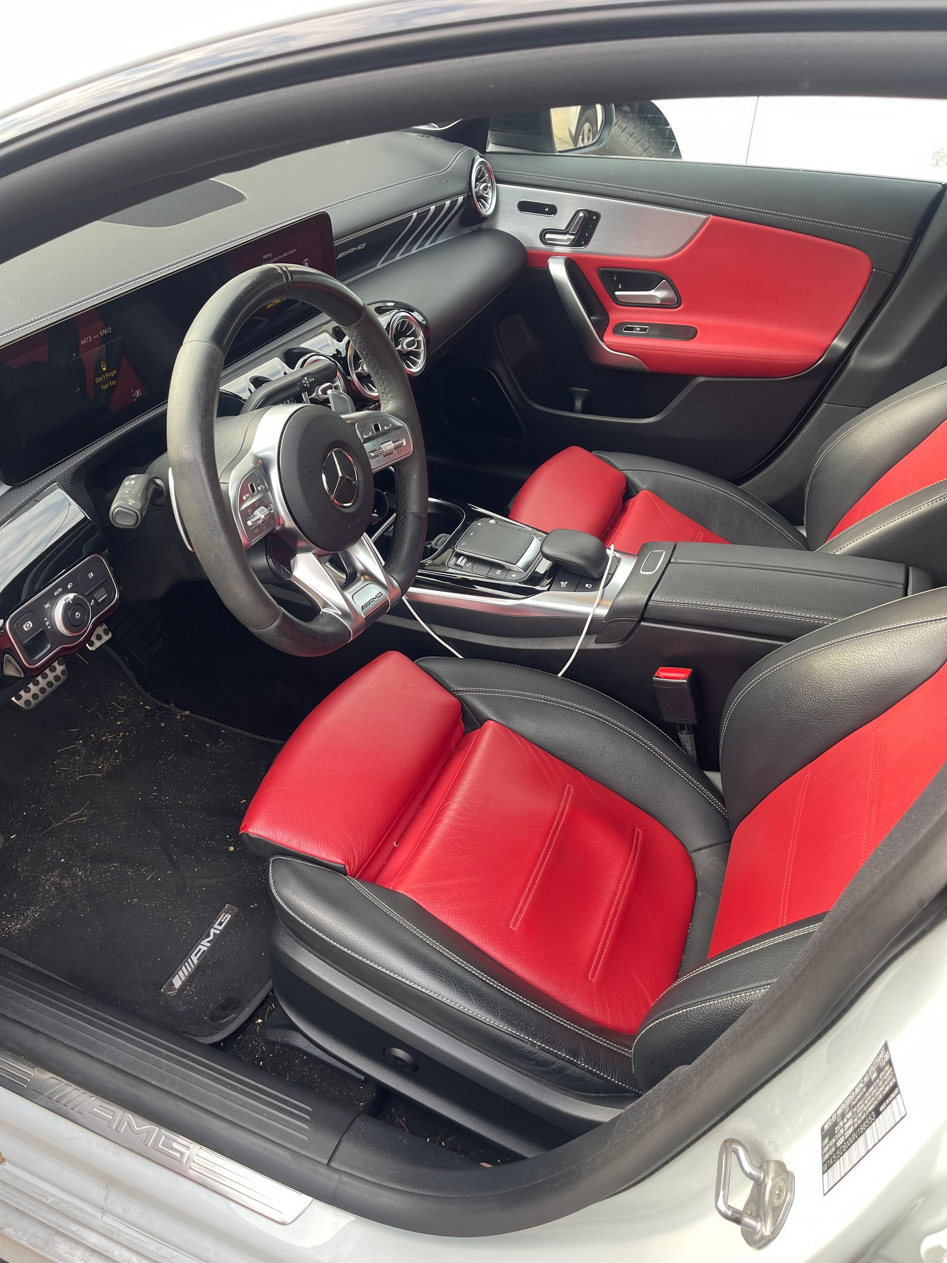 Red and black leather interior of a Mercedes-Benz car, with a silver steering wheel and dashboard. | Benz Tech