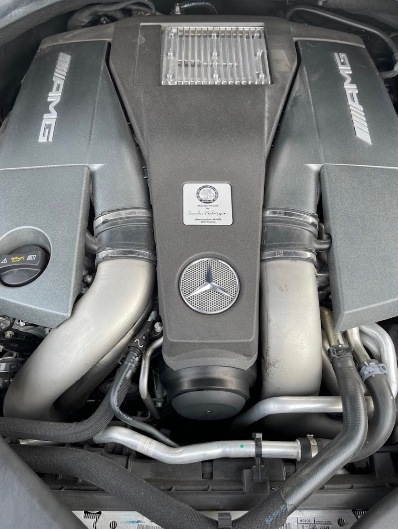 Mercedes-AMG engine with silver components, black cover, and AMG branding. | Benz Tech