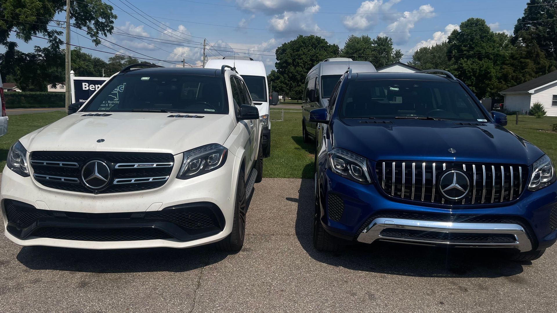 Two Mercedes SUVs, white and blue, parked outdoors on a sunny day. | Benz Tech