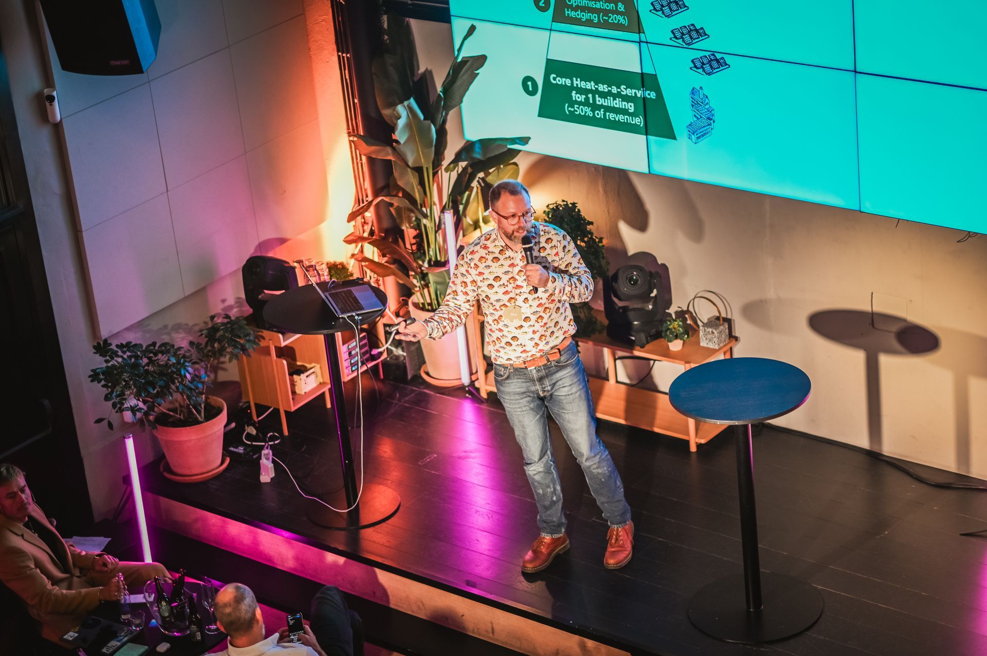 Waterfront cityscape with white buildings, red roofs, a church tower, and a calm body of water.