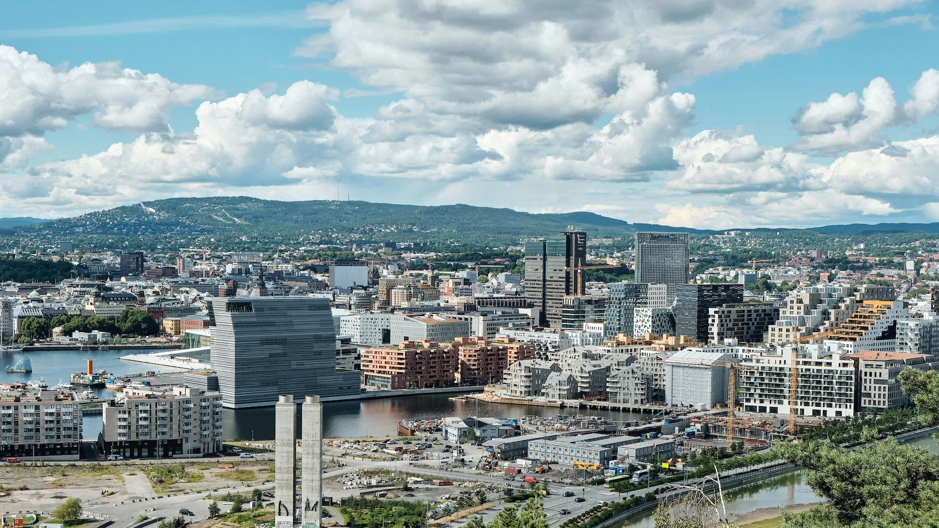 Street in Stavanger, Norway, lined with colorful buildings. Church spire visible, under an orange sunset.