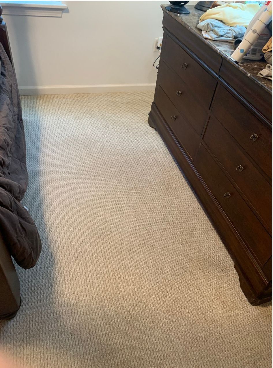 A bedroom with a bed , dresser , and carpet.