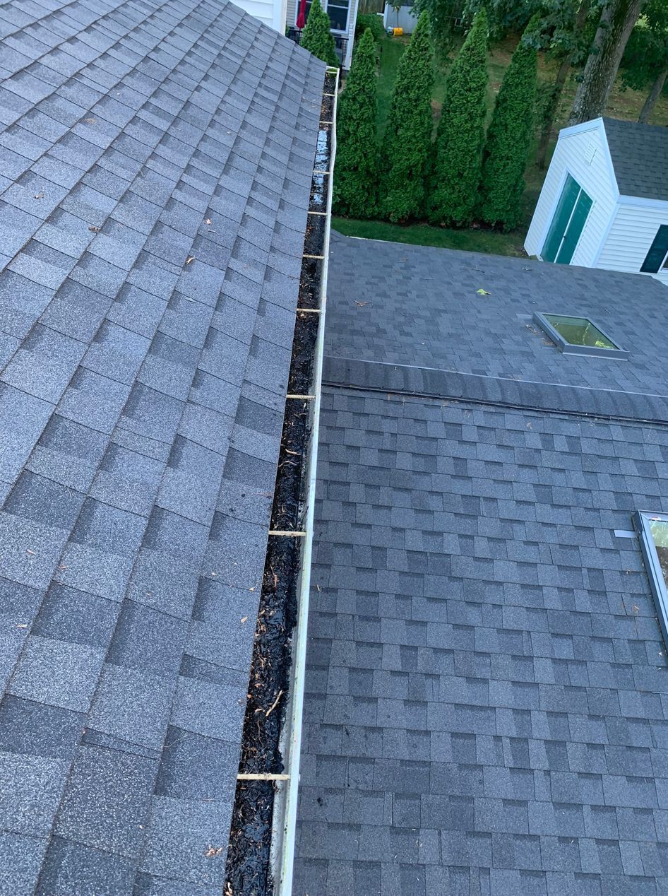 There is a gutter on the roof of a house.
