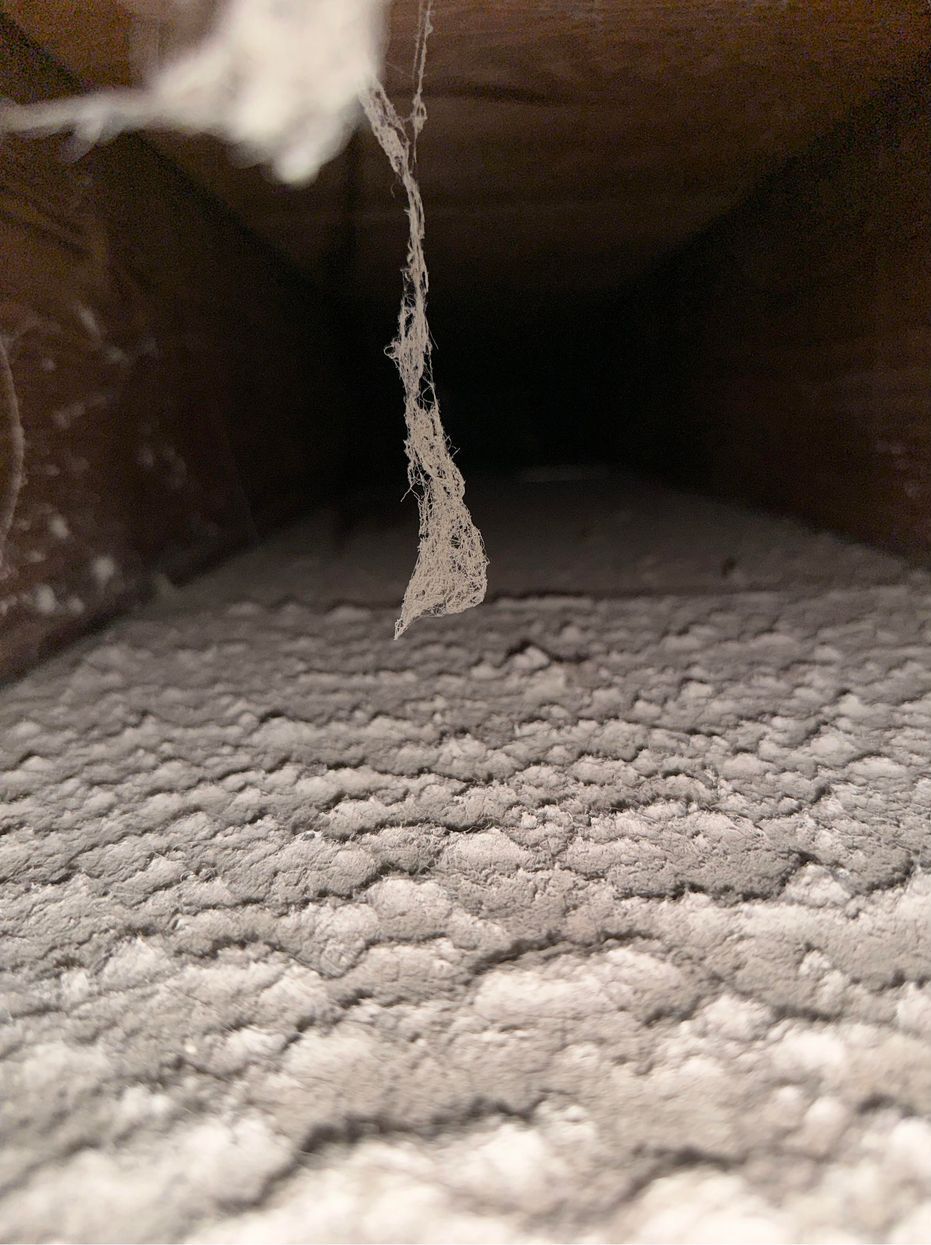 A close up of a dirty air vent in a house.
