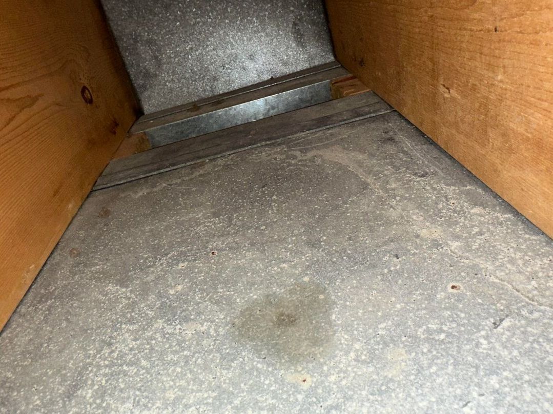 A close up of a metal duct in a wooden box.