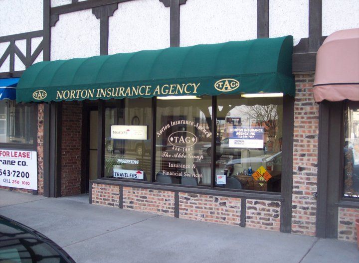 Norton Insurance Agency storefront with green awning, windows, and brick facade.