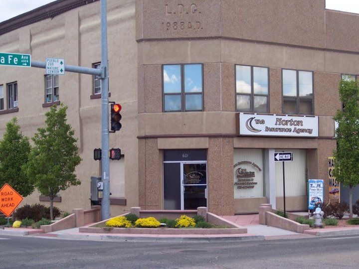 Corner building: The Horton Insurance Agency sign, street signs, flowers, and traffic lights.