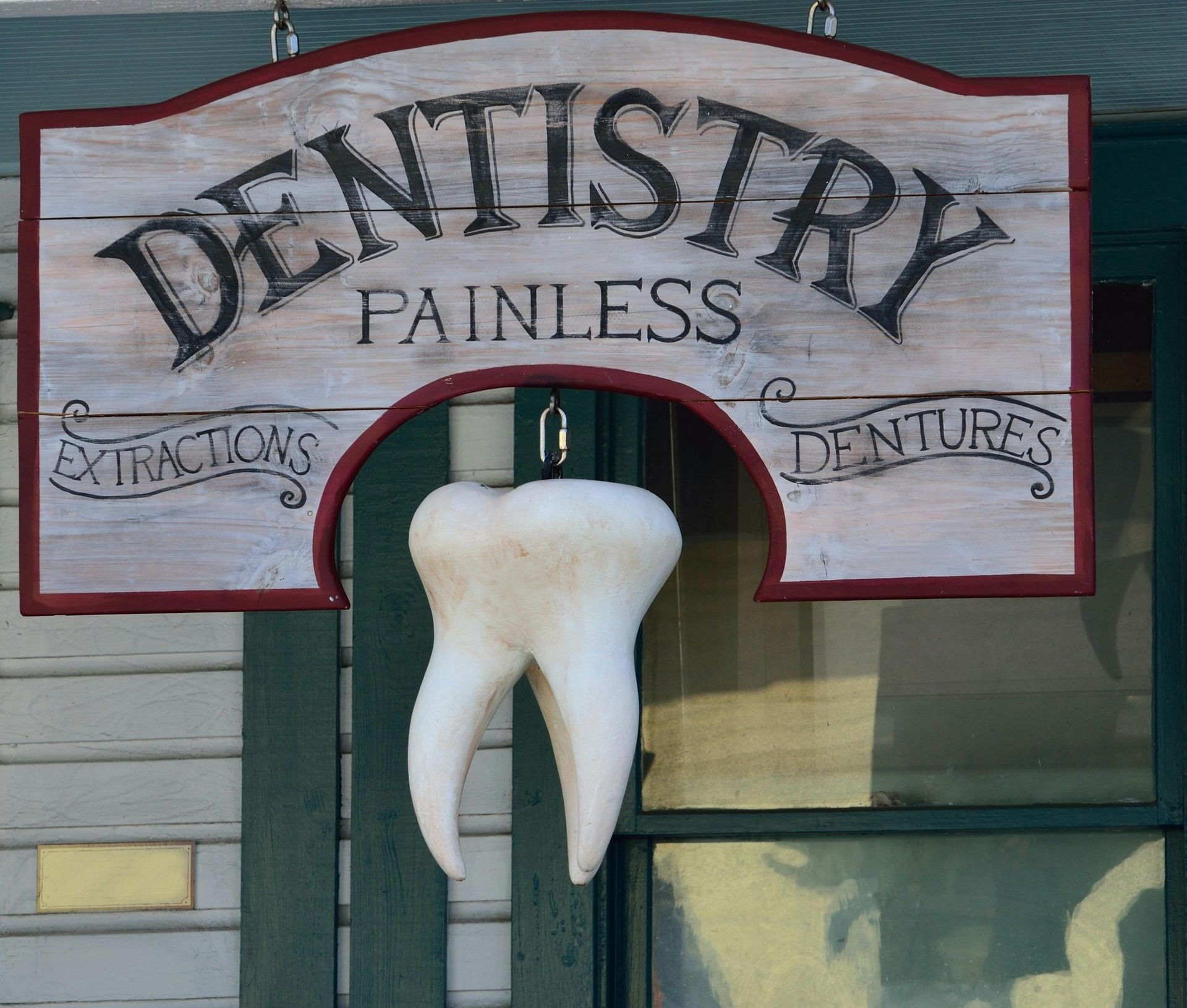 A wooden sign for dentistry painless dentures
