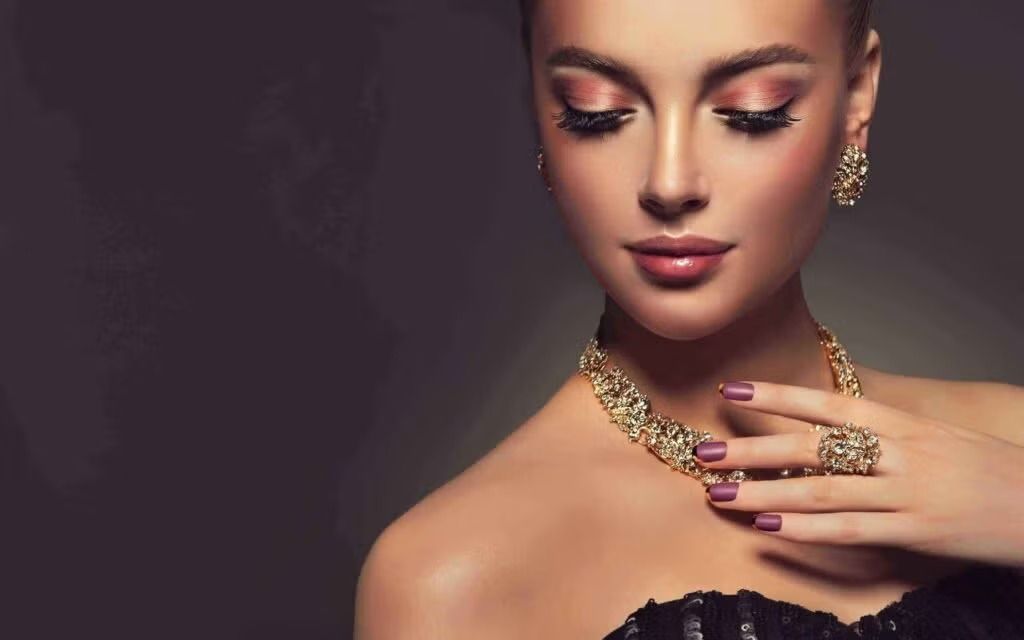 Elegant portrait of a woman wearing gold jewelry against a dark background