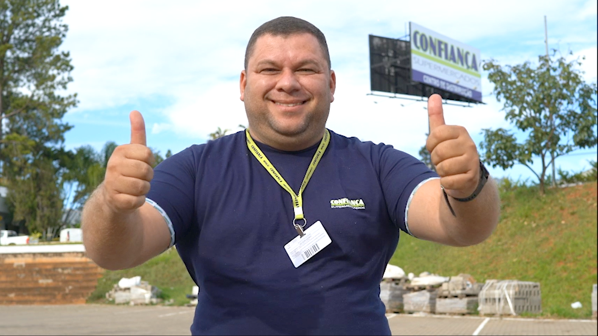 Um homem de camisa azul está fazendo sinal de positivo