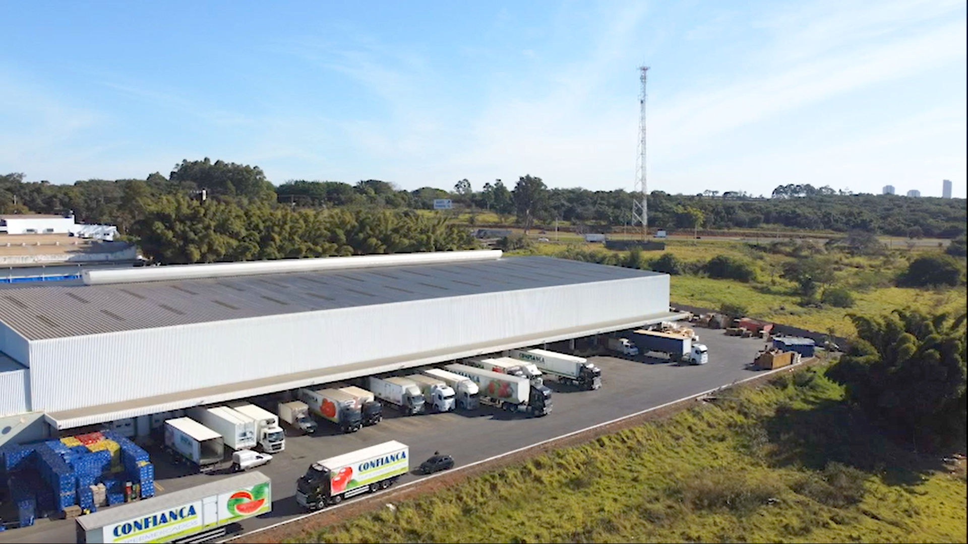 Uma vista aérea de um armazém com caminhões estacionados em frente.